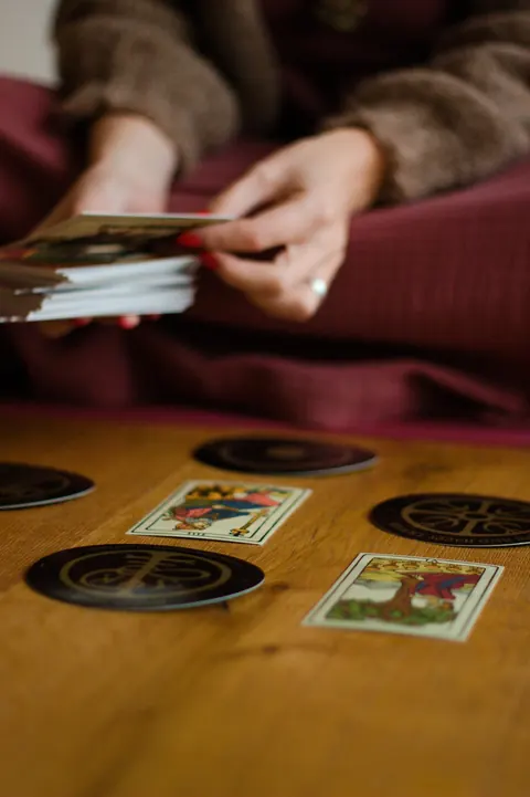 Rezi's hands shuffling tarot cards during a reading
